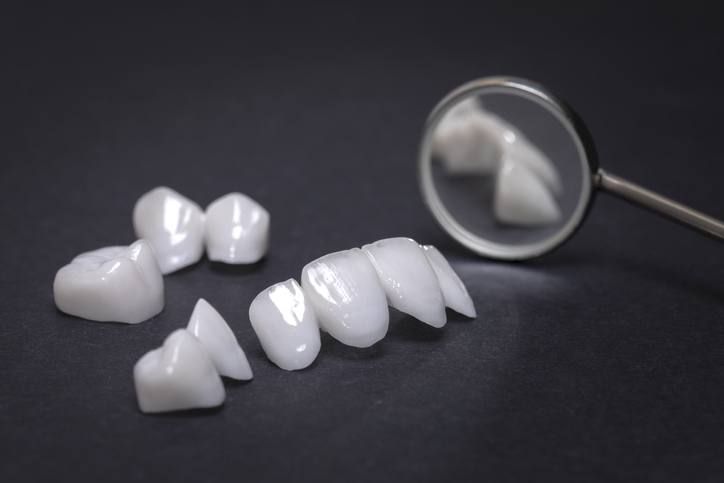 Dental mirror with zircon dentures on a dark background - Ceramic veneers - lumineers